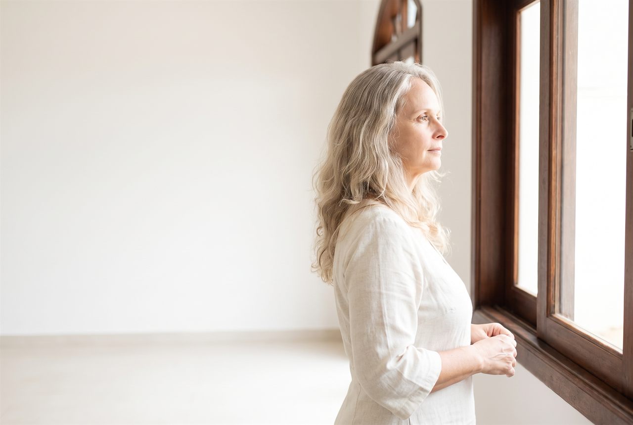 Marcia Rosa olhando pela janela, em silêncio